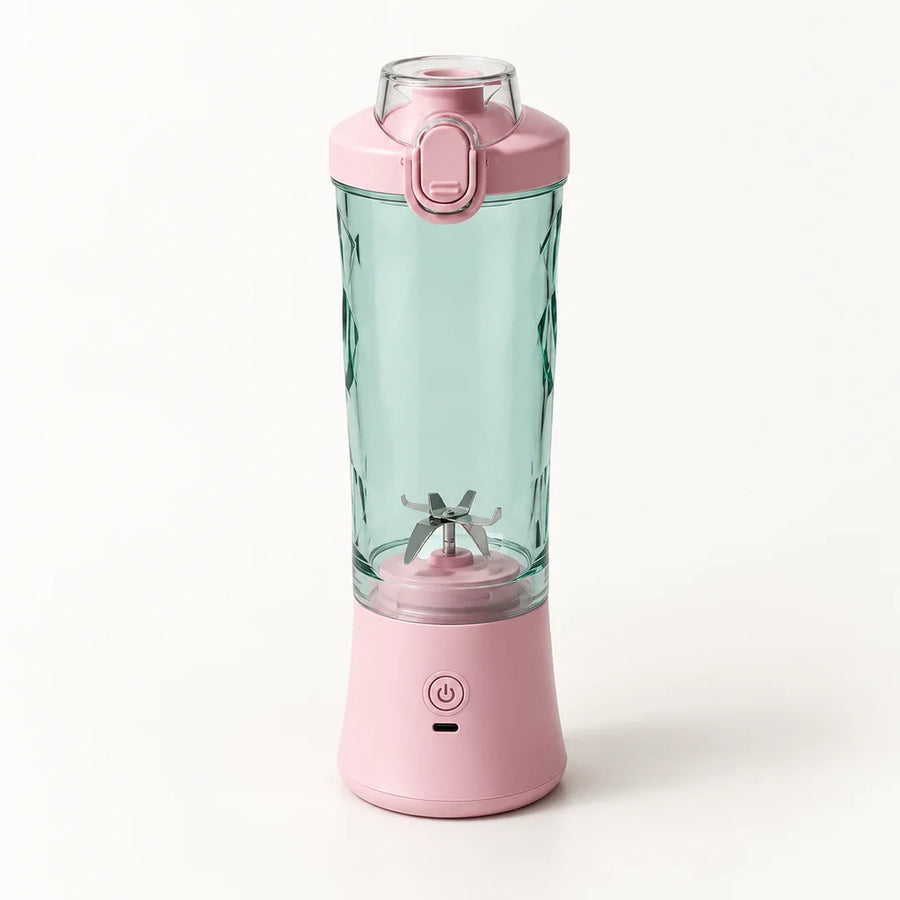 Blender portable 600 ml rose avec gobelet vert d'eau à facettes et couvercle rose à clapet, sur fond blanc cassé