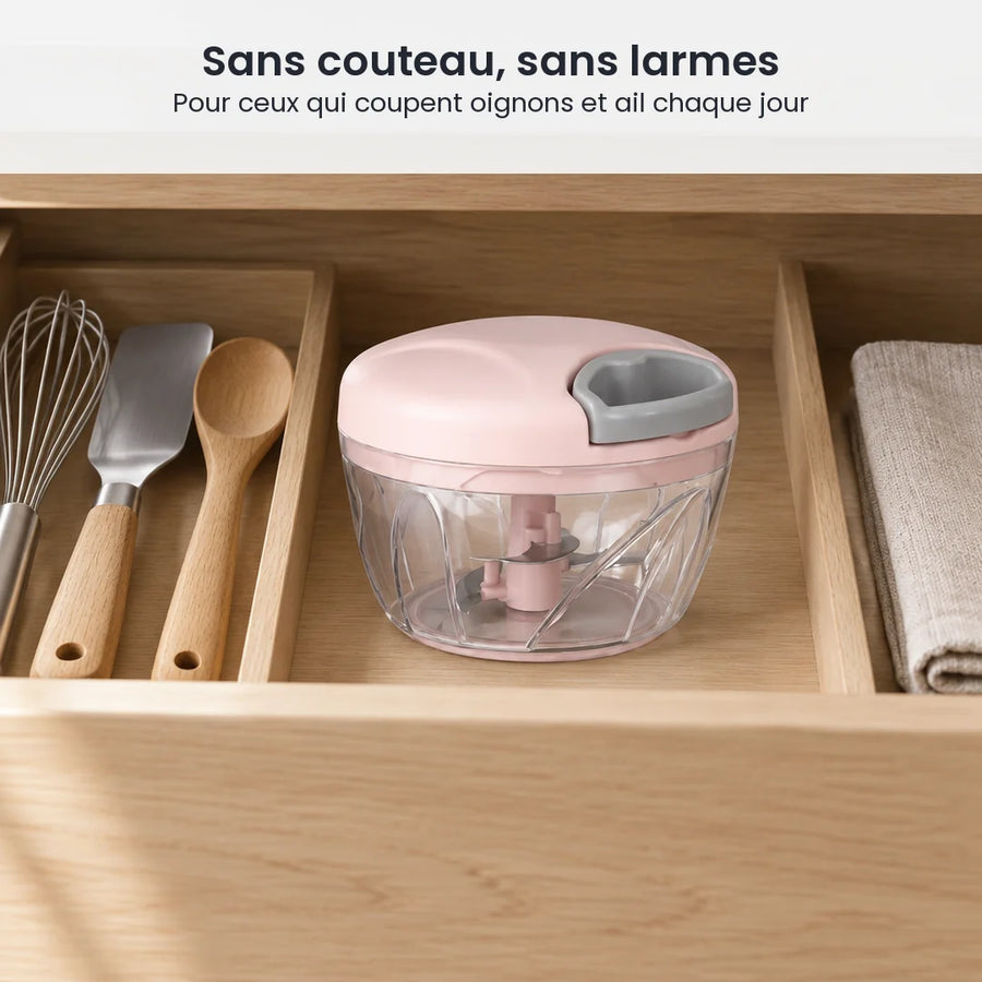 Hachoir manuel à ficelle 500 ml rose poudré rangé dans un tiroir de cuisine, à côté d'ustensiles et d'un torchon
