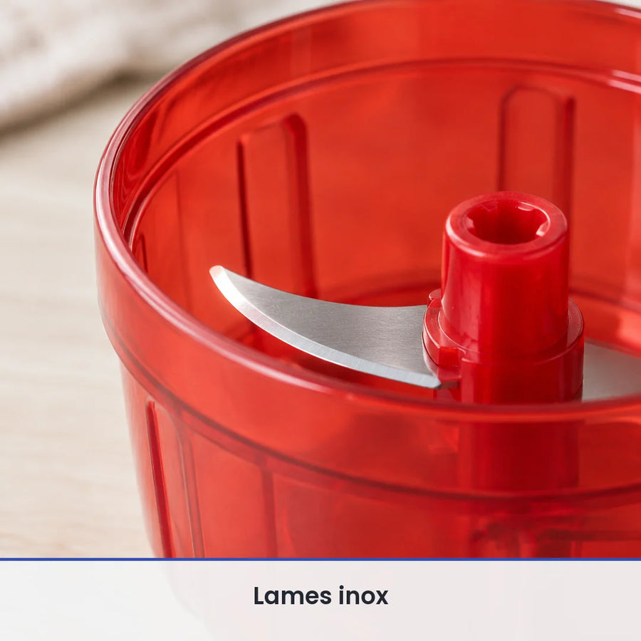 Gros plan sur la lame inox fixée sur l'axe du bol rouge translucide ouvert du hachoir manuel compact à ficelle