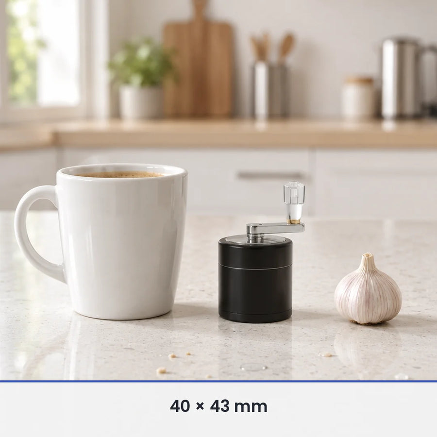 Petit moulin à épices noir de 40 × 43 mm à côté d'une tasse à café et d'une tête d'ail, pour donner l'échelle