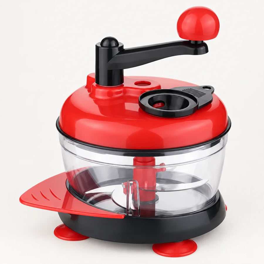 Hachoir manuel à manivelle rouge à bras noir et boule rouge, bol transparent, ventouses et raclette rouges, fond blanc cassé