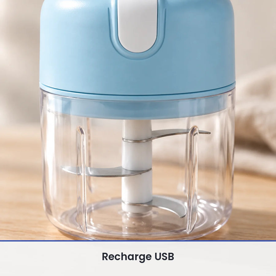Gros plan sur le couteau inox à trois lames du mini hachoir bleu ciel, vu à travers la paroi du bol transparent fermé