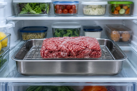 Viande hachée crue en train de décongeler sur une grille dans un bac au réfrigérateur