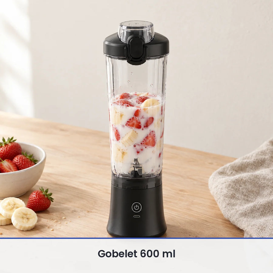 Gobelet du blender portable noir 600 ml rempli aux deux tiers de fraises, de banane et de lait, sur un banc en bois clair