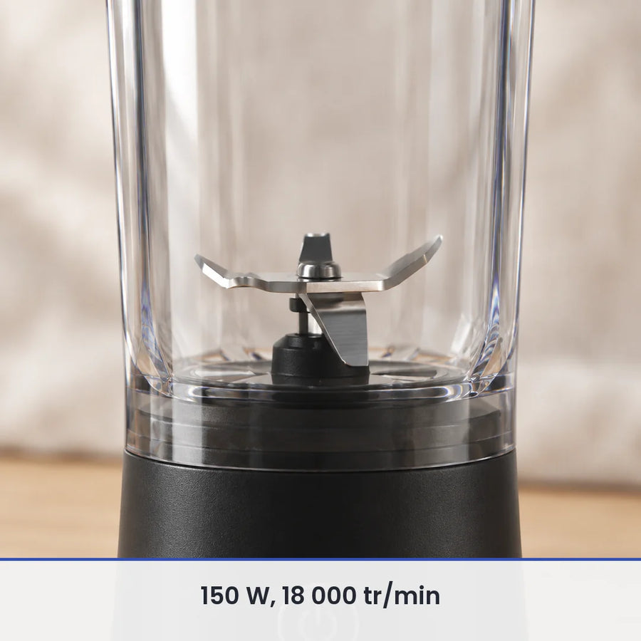 Gros plan sur les lames inox du blender portable noir 600 ml, vues à travers la paroi du gobelet transparent fermé