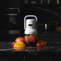 Blender portable Zhenmi violet sur marbre noir, entouré de mangue et fraises fraîches, éclairage cinématique