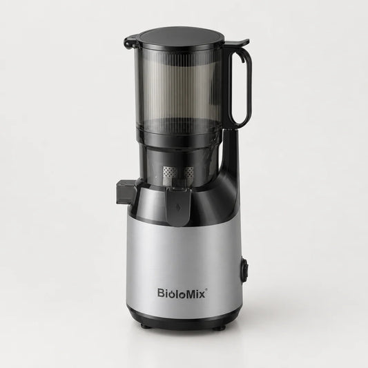 Extracteur de jus BioloMix argenté et noir avec grande trémie transparente fumée à poignée, sur fond blanc cassé