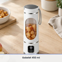 Blender portable blanc 450 ml rempli de morceaux de pommes cuites, posé sur un plan de travail en bois clair