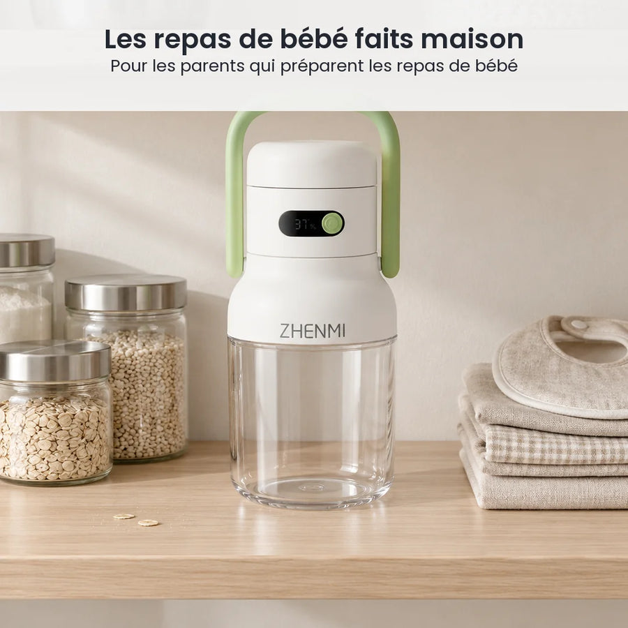 Mini blender à anse verte, bol transparent vide, rangé sur une étagère claire à côté de bocaux et de bavoirs pliés