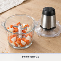 Bol en verre de 2 L du hachoir électrique 300W rempli d'oignons et de carottes, bloc moteur posé à côté