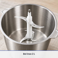 Gros plan sur la double lame inox montée sur son axe blanc dans le bol inox ouvert du hachoir BioloMix 500W