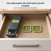 Coupe-légumes 14 en 1 gris anthracite rangé dans un tiroir de cuisine clair, deux grilles de découpe vertes à côté
