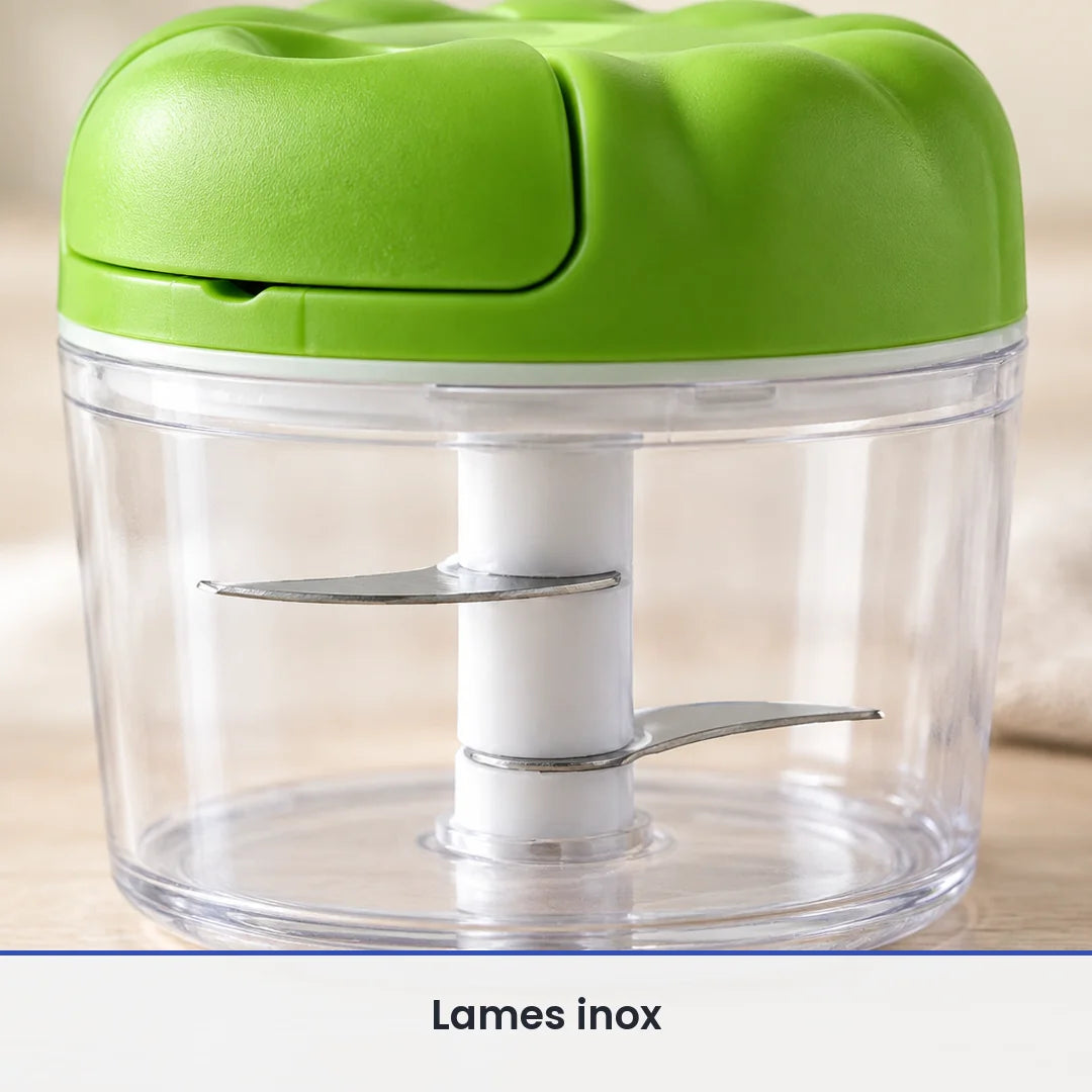 Gros plan sur les lames inox fixées sur l'axe blanc du hachoir compact vert pomme, vues à travers le bol transparent