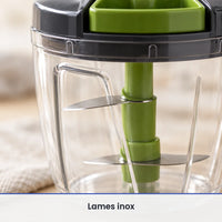 Gros plan sur les lames inox fixées sur l'axe vert du hachoir à ficelle 1 000 ml, vues à travers le bol transparent