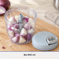 Grand bol transparent de 900 ml du hachoir à ficelle rempli d'oignons rouges en quartiers, couvercle bleu-gris à côté