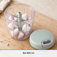 Grand bol transparent de 900 ml du hachoir à ficelle rempli d'oignons coupés en quatre, couvercle vert menthe à côté