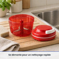Bol rouge translucide et lame du hachoir compact lavés sur un égouttoir près de l'évier, couvercle à ficelle posé au sec