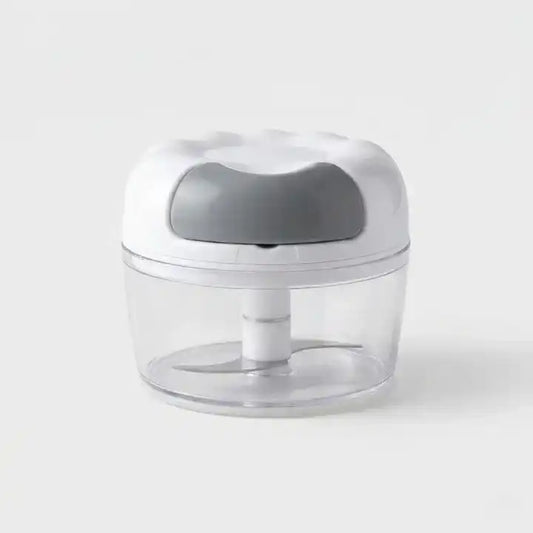 Hachoir manuel à ficelle violet compact pour légumes en situation d'utilisation