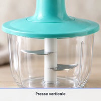 Gros plan sur les lames inox fixées sous la collerette turquoise du hachoir à presse, vues à travers le bol transparent