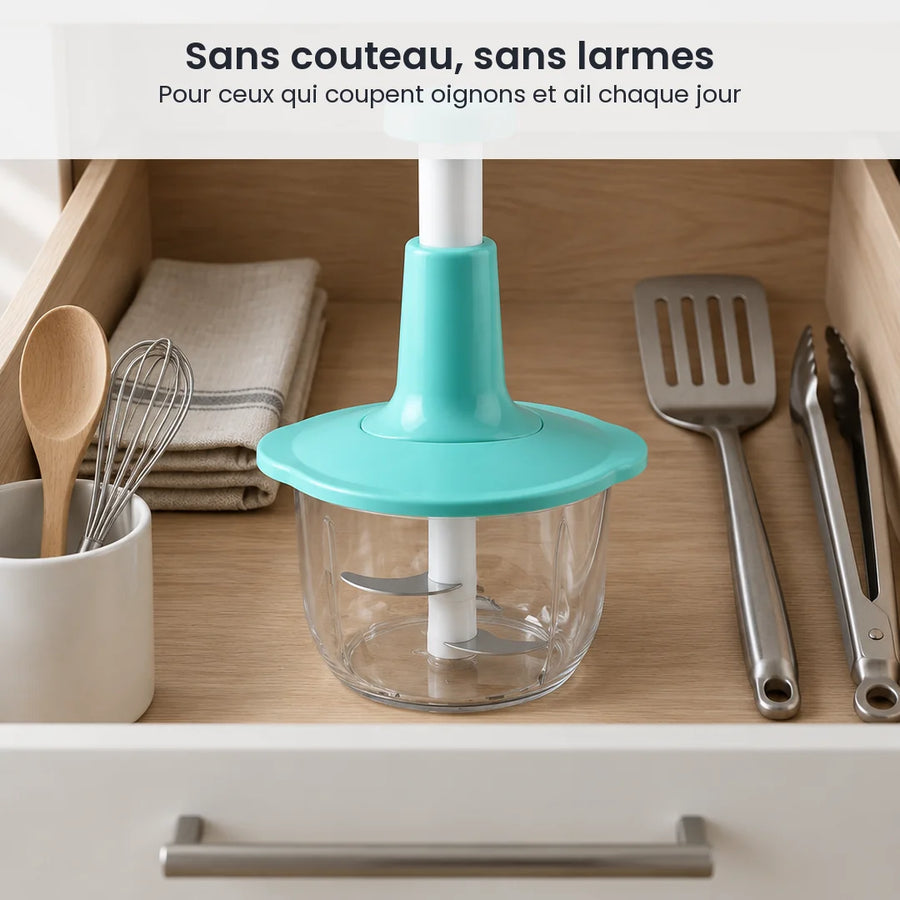 Hachoir à presse verticale turquoise rangé dans un tiroir de cuisine, entre spatule, fouet et cuillère en bois