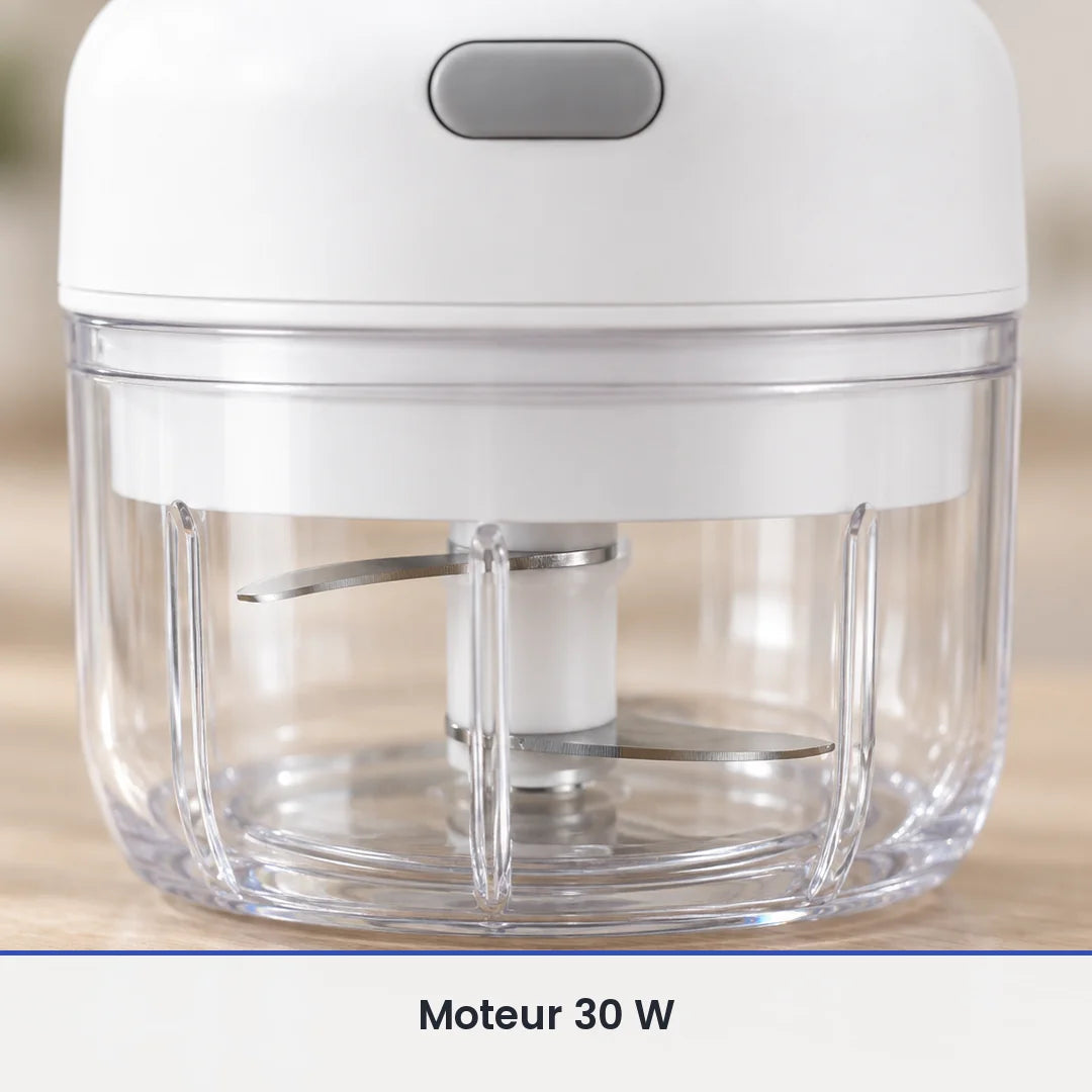 Gros plan sur les lames inox du mini hachoir électrique blanc, vues à travers la paroi du bol transparent de 100 ml fermé