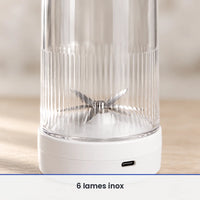 Gros plan sur les 6 lames inox du blender bouteille blanc, vues à travers la paroi striée de la bouteille transparente