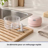 Bol transparent et couteau du mini hachoir électrique rose lavés sur un égouttoir près de l'évier, moteur posé au sec