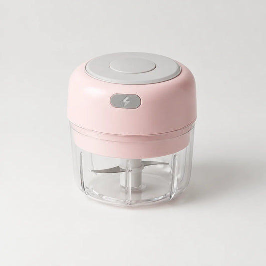 Mini hachoir électrique rose poudré 30 W avec bol transparent de 100 ml et bouton gris à éclair, sur fond blanc cassé