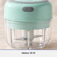 Gros plan sur les lames inox du mini hachoir électrique vert menthe, vues à travers le bol transparent de 100 ml fermé