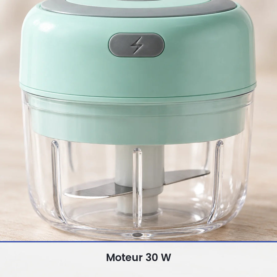 Gros plan sur les lames inox du mini hachoir électrique vert menthe, vues à travers le bol transparent de 100 ml fermé