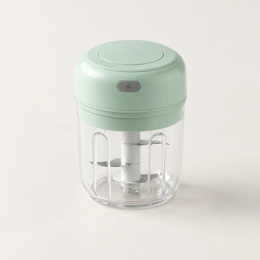 Mini hachoir électrique vert menthe 30 W avec bol transparent de 250 ml et bouton gris à éclair, sur fond blanc cassé