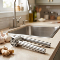 Presse-ail inox à manches tubulaires, panier amovible, en situation dans la cuisine